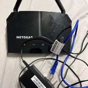 GUC Netgear AC1200 WiFi Router with AC adapter and Ethernet cable.